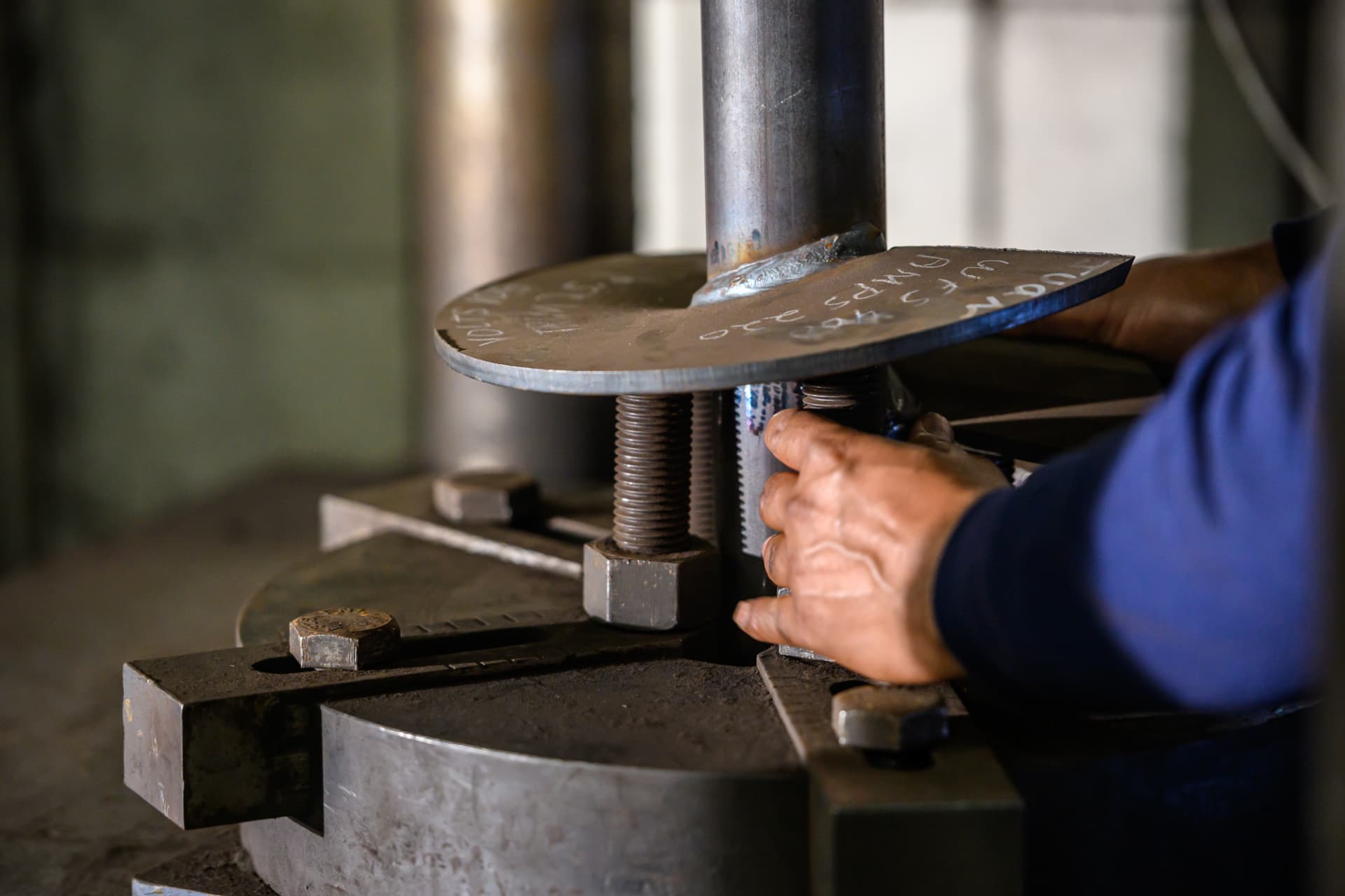 Hand adjusting a welded helix plate on a test fixture